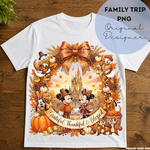 May include: A white t-shirt featuring a colorful autumn-themed graphic of Disney characters including Mickey, Minnie, Donald, Daisy, Goofy, and Pluto. The design includes a large orange bow, a castle, pumpkins, and the text Grateful, Thankful & Blessed.