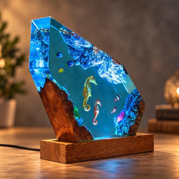 A hand-poured epoxy resin lamp encasing real seahorse and Blue Tang fish scenes in glowing ocean-blue wood — it's basically a lit aquarium you put on your desk.