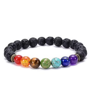 Può includere: Un braccialetto di perline composto da una serie di perle di pietra lavica nera porosa e sette perle di pietre dure lisce e colorate in rosso, arancione, marrone, verde, turchese, blu e viola, con due distanziatori metallici a coste.