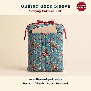 Puede incluir: Un patrón de costura PDF para una funda de libro acolchada en tela azul verdoso con estampado de flores y cerezas, costuras verticales y un lazo de cierre rojo oscuro. El texto dice Quilted Book Sleeve Sewing Pattern PDF, Instant Download y needlenookpatterns.
