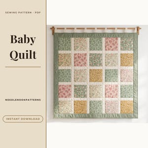 May include: A square baby quilt featuring a grid of floral patterned fabric squares in shades of pink, yellow, and green, separated by white sashing and framed by a sage green border, hanging from a wooden rod with fabric loops.