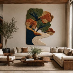 May include: A large, textured wall hanging featuring an abstract landscape design with tufted fibers in shades of forest green, burnt orange, deep navy blue, and cream. The piece displays organic, layered shapes resembling trees and a winding path.
