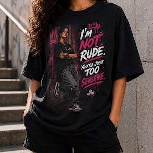 May include: A black short-sleeved t-shirt featuring a graphic print of a person leaning against a wall. The text reads I'M NOT RUDE. YOU'RE JUST TOO SENSITIVE. The design includes pink crown accents and the brand name MAREXO in white and pink.