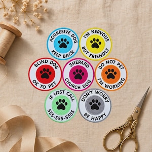May include: Seven circular embroidered patches with black paw prints and text. The patches are light blue, yellow, red, pink, orange, light green, and gray. Text includes AGGRESSIVE DOG KEEP BACK, I'M NERVOUS BUT FRIENDLY, BLIND DOG OK TO PET, SHEPARD CHURCH DOG, DO NOT PET I'M WORKING, IF LOST CALL 555-555-5555, and DON'T WORRY BE HAPPY.