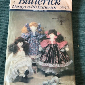 May include: A vintage sewing pattern for making three dolls. The pattern is from Butterick and is number 5949. The dolls are dressed in floral print dresses and have long hair. The pattern includes instructions for making the dolls and their clothing.