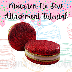 May include: Two red glitter macarons with a gold trim. The macarons are stacked on top of each other. The background is a pink and white pattern with sprinkles.