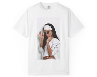 May include: A white short-sleeved t-shirt featuring a centered rectangular graphic print of a person wearing a white patterned bandana, dark sunglasses, a white top, and a white jacket, with a small Comfort Colors brand tag at the inner neckline.