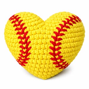 Puede incluir: Una pelota de softbol en forma de corazón, tejida en amarillo con costuras rojas. Este artículo decorativo es una versión única de un artículo deportivo clásico. El diseño hecho a mano añade un toque de encanto.