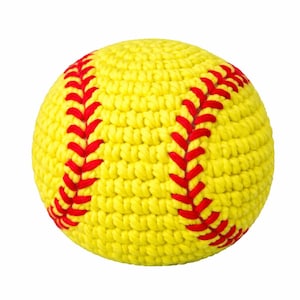 Puede incluir: Una pelota de softbol amarilla hecha a mano con costuras rojas. La pelota está tejida a ganchillo, mostrando una superficie texturizada. Las costuras rojas están dispuestas en un patrón clásico.