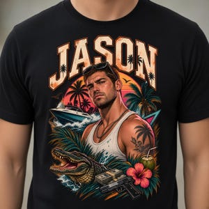 May include: A black t-shirt featuring a graphic print of a man in a white tank top, the name JASON in large letters, a speedboat, an alligator, a stack of cash, a handgun, a coconut drink, a hibiscus flower, and palm trees in a sunset scene.