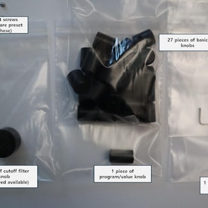 May include: A collection of black electronic control components in clear plastic bags, including 27 basic knobs, one cutoff filter knob, one program value knob, one modulation slider, an Allen wrench, and a set of spare set screws for the knobs.