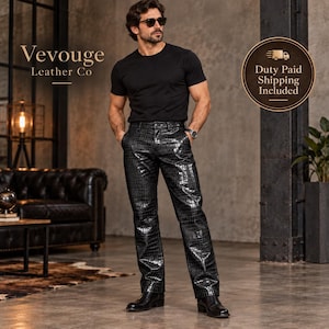 May include: Black trousers featuring a glossy, embossed crocodile skin texture. The trousers have a straight-leg cut, a standard waistband with belt loops, and a button-fly closure. The material has a reflective finish, highlighting the pattern.
