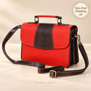 Peut inclure: Un sac à main rectangulaire doté d'un corps rouge vif avec un panneau central texturé en peau de serpent marron foncé et une bandoulière assortie. Le sac comprend une poignée supérieure, des ferrures en laiton vieilli et des surpiqûres blanches.