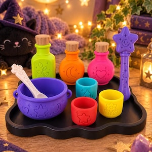 Puede incluir: Un juego de juguetes de silicona de colores para hacer pociones que incluye un caldero morado con una cuchara blanca, tres botellas con tapones de madera en verde lima, naranja y rosa, una varita morada con estrella y tres vasos pequeños en azul, rojo y amarillo.