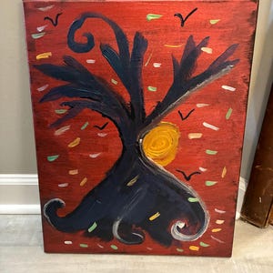 May include: A rectangular canvas painting featuring a dark blue, stylized tree with swirling branches centered against a vibrant red background. A bright yellow circular sun is positioned behind the tree, surrounded by small black bird silhouettes and scattered dashes of green, white, and gold paint.