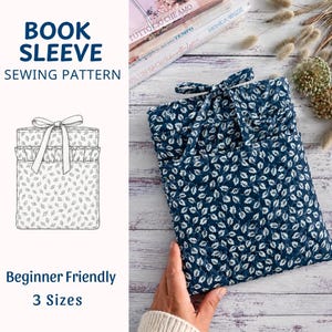 May include: A quilted fabric book sleeve featuring a dark blue background with a white leaf pattern, a ruffled top edge, and a fabric tie closure. The image includes text reading BOOK SLEEVE SEWING PATTERN, Beginner Friendly, and 3 Sizes.