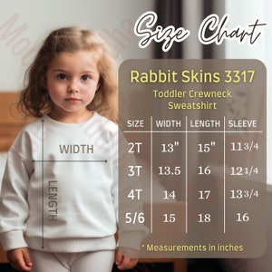 Könnte beinhalten: Größentabelle für einen Kapuzenpullover für Kleinkinder von Rabbit Skins, mit Maßen in Zoll für die Größen 2T, 3T, 4T und 5/6. Die Tabelle zeigt die Maße für Breite, Länge und Ärmel.