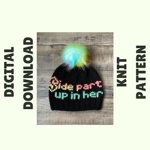 May include: Black knit beanie with a rainbow colored "Side part up in her" text and a fluffy multi-colored pom pom.