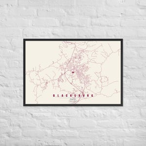 May include: A framed map print of Blacksburg, Virginia, featuring maroon street lines on a cream background. A small maroon heart marks a central location. The text reads BLACKSBURG, VIRGINIA TECH, and coordinates in a clean, sans-serif font.