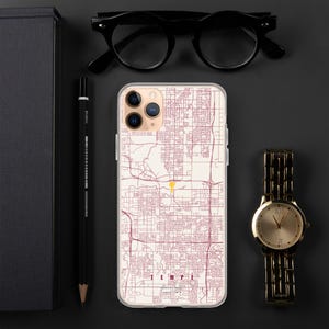 May include: A smartphone case featuring a detailed street map of Tempe, Arizona, in maroon lines on a cream background. A small yellow location pin marks a specific spot on the map. The text TEMPE is printed at the bottom in maroon capital letters.