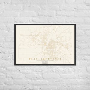 May include: A framed map print of West Lafayette featuring a cream background with tan street lines. The text reads WEST LAFAYETTE, PURDUE UNIVERSITY, and coordinates. A small tan heart icon marks a specific location on the map grid.