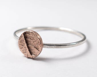 May include: A silver band ring with a textured copper circle on top.