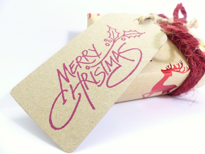 May include: A brown paper gift tag with a red "Merry Christmas" message and a holly sprig design.