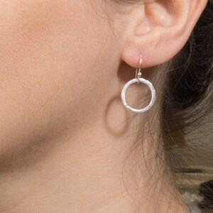 May include: Silver hammered circle earrings with a simple hook closure.