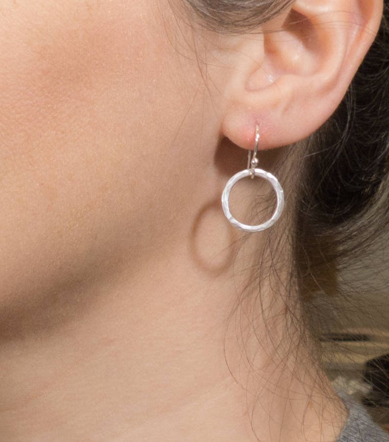 May include: Silver hammered circle earrings with a simple hook closure.