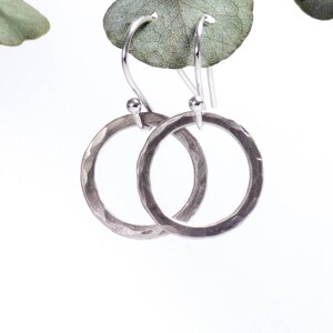 May include: A pair of silver hammered circle earrings with a simple hook closure.