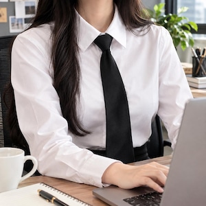 May include: A crisp white long-sleeved button-down shirt featuring a classic pointed collar and a solid black necktie. The shirt is tailored with a structured fit, long sleeves with buttoned cuffs, and a smooth fabric finish, providing a formal look.