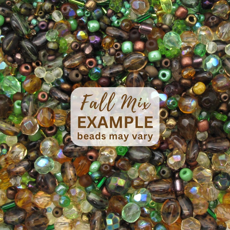 K&ouml;nnte beinhalten: Eine Sammlung verschiedener Perlen in Braun-, Gr&uuml;n- und Bernsteint&ouml;nen mit unterschiedlichen Formen, Gr&ouml;&szlig;en und Oberfl&auml;chen. Ein wei&szlig;es Etikett in der Mitte zeigt den Text Fall Mix EXAMPLE beads may vary in brauner Schrift &uuml;ber den Perlen.