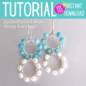 May include: A pair of silver hoop earrings with turquoise and white beads. The earrings are embellished with wire and have a simple, elegant design.
