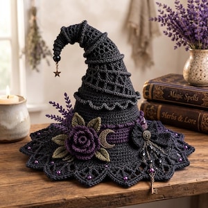 May include: A dark charcoal crochet witch hat featuring a pointed top with a dangling star charm. The hat is adorned with a deep purple crocheted rose, green leaves, a gold crescent moon charm, a black bow, and a dangling key with purple beads.
