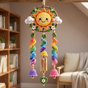 Peut inclure: Une suspension en crochet composée d'un soleil jaune central au visage souriant, entouré de deux nuages blancs et de petites fleurs blanches sur un anneau marron. Trois spirales arc-en-ciel pendent en dessous avec deux clochettes et un carillon.