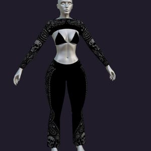 Könnte beinhalten: Ein schwarzes Set aus bauchfreiem Langarmshirt und ausgestellter Hose mit weißem Paisley- und Totenkopfmuster. Das Outfit beinhaltet ein schwarzes Triangel-Bikini-Oberteil, das unter dem bauchfreien Langarmshirt an einer Schaufensterpuppe getragen wird.