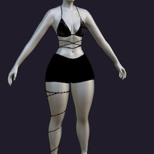 Könnte beinhalten: Ein schwarzes Spitzen-Bikini-Oberteil mit dünnen Trägern, die um den Oberkörper gewickelt sind, kombiniert mit einer einfarbigen schwarzen Shorts. Ein dekoratives Kettenaccessoire mit kleinen roten Akzenten ist um das rechte Bein gewickelt.