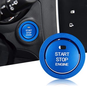 Puede incluir: Una cubierta circular de metal azul para el botón de arranque y parada del motor con el texto blanco START STOP ENGINE y un pequeño recorte rectangular en la parte superior. El accesorio está diseñado para un botón de encendido de vehículo.