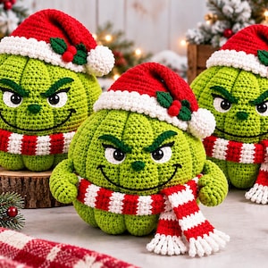 Puede incluir: Tres figuras redondas de ganchillo en color verde lima con superficies texturizadas, cada una con una expresión facial gruñona, ojos negros bordados y una boca fina. Cada figura lleva un gorro de Papá Noel y una bufanda a rayas rojas y blancas.