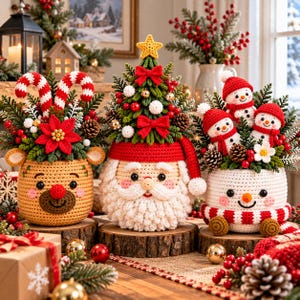May include: Three crocheted holiday containers featuring a tan reindeer, a Santa Claus with a Christmas tree topper, and a white snowman. Each container is filled with festive greenery, red berries, pinecones, and candy canes.