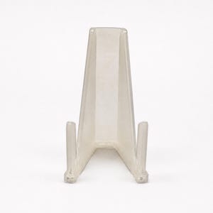 May include: A clear, transparent plastic display stand featuring a tall, angled back support and two forward-projecting arms designed to hold items upright. The stand has a smooth, molded construction with a wide base for stability and a minimalist profile.