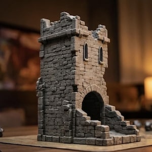 May include: A gray stone dice tower featuring a textured brick pattern, a large arched entrance at the base, and two small arched windows near the top. The structure has a weathered, ruined appearance with uneven edges along the parapet walls.