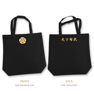 Peut inclure: Un sac fourre-tout noir avec un emblème familial Oda doré sur le devant et le texte japonais Tenka Fubu doré au dos. Le sac possède deux anses noires et un corps rectangulaire, présentant les deux côtés du même article.