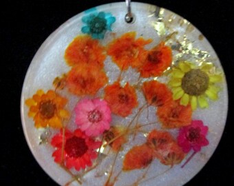 Round pendant with pressed flowers white background