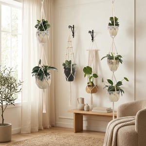 May include: A collection of macrame plant hangers featuring off-white cotton cord, wooden beads, and tassels. The hangers hold various ceramic pots with blue and white floral patterns, as well as a woven basket, suspended from ceiling hooks.