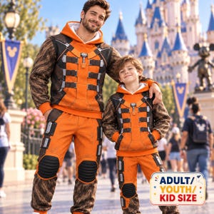 May include: Matching orange and brown hooded sweatshirts and pants featuring a textured fur-like pattern on the sleeves and legs, black knee pads, and a graphic print of mechanical straps and buckles. A label reads ADULT/YOUTH/KID SIZE.