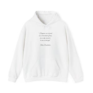 Peut inclure: Un sweat-shirt à capuche blanc à manches longues avec une poche kangourou sur le devant et une citation imprimée en noir : "Happiness can be found, even in the darkest of times, if one only remembers to turn on the light." et "Albus Dumbledore".