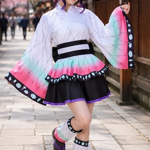 May include: A costume featuring a white kimono-style top with black geometric lines, a black obi belt, and a flared skirt with a pink and teal gradient hem. The outfit includes wide sleeves with butterfly-wing patterns, leg warmers, and dark sandals.