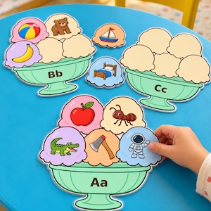 May include: Three educational ice cream bowl cutouts featuring letters Aa, Bb, and Cc. The bowls contain scoops with illustrations of an apple, ant, alligator, axe, astronaut, beach ball, bear, banana, boat, and bed, printed on cardstock.