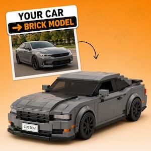 Op de afbeelding: Een grijs modelauto gemaakt van in elkaar grijpende plastic blokjes, met zwarte wielen, getinte ramen en een voorste nummerplaat met de tekst CUSTOM. Boven de auto staat een foto van een grijze sedan met de tekst YOUR CAR BRICK MODEL.